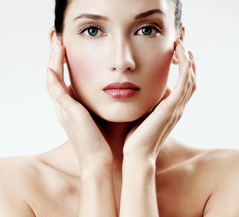 A woman with hands touching both sides of her face